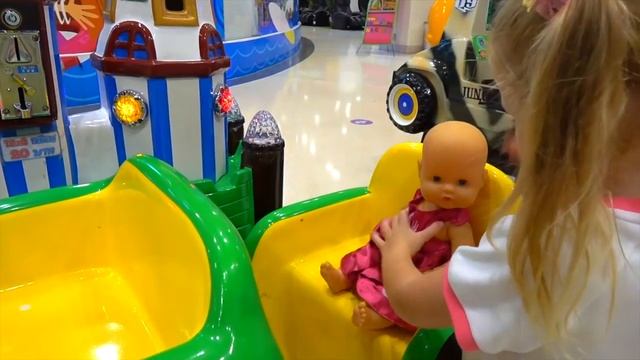кукла играет на детской площадке